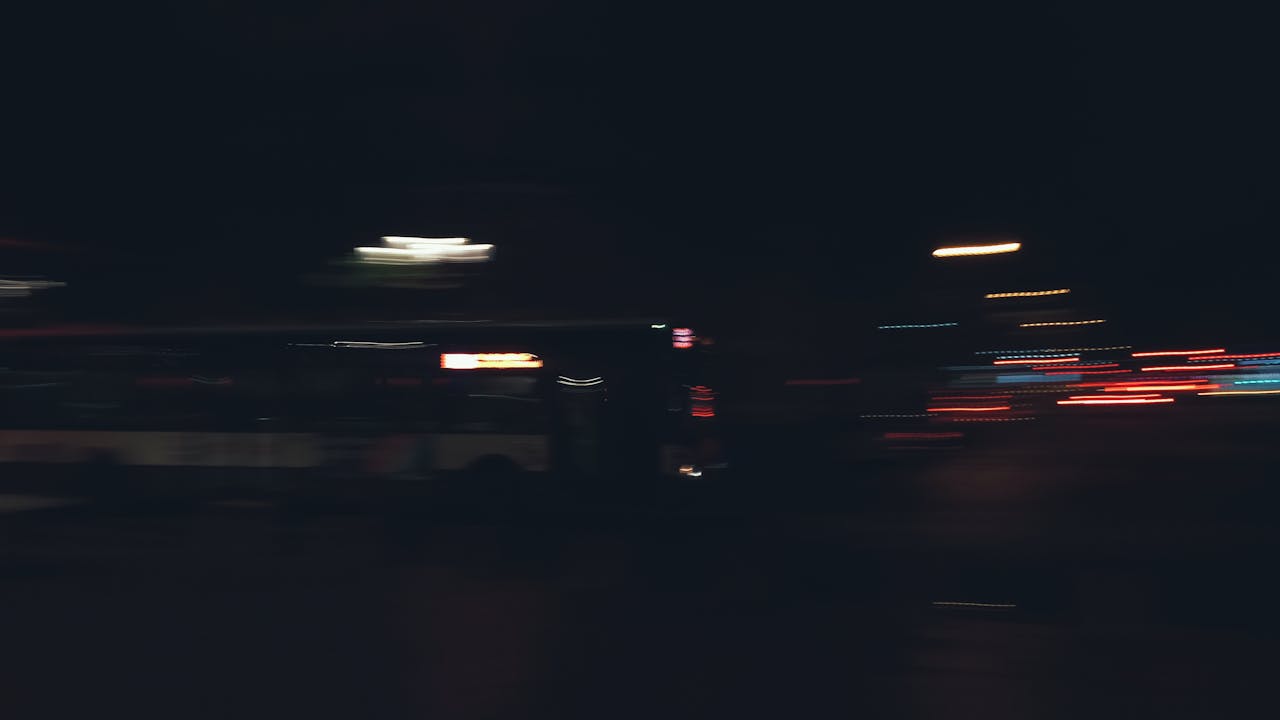 A dynamic nighttime shot capturing blurred traffic lights and motion in Paris, France.